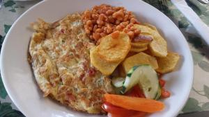 a plate of food with a omelet and beans and chips at Agip Motel Mbarara in Mbarara