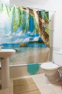 een badkamer met een tropisch douchegordijn voor het strand bij EURO CARISSA FLAT 101 in Larnaka