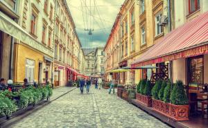 a group of people walking down a street with buildings at Apartment on Lychakivska in Lviv