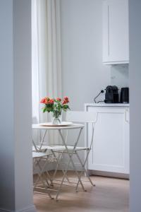 a table with a vase of flowers on it in a kitchen at Apartament Jola in Sopot