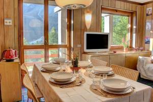 a dining room with a table with chairs and a television at Marcolski Home 2 in Breuil-Cervinia