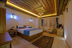 a bedroom with a bed with a wooden ceiling at Termessos Hotel in Goreme