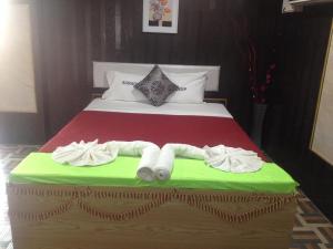 a bedroom with a bed with towels on it at suradeep residency in Mahabalipuram