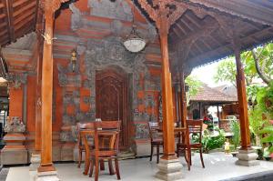 una mesa y sillas frente a un edificio en Astiti Guest House Salon and Spa, en Ubud
