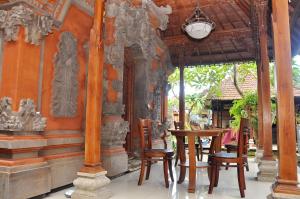 una mesa y sillas frente a un edificio en Astiti Guest House Salon and Spa, en Ubud