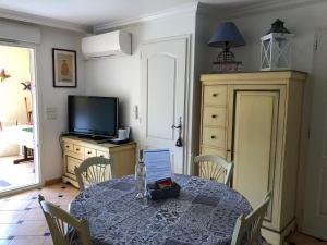 une salle à manger avec une table et une télévision dans l'établissement Le Noisetier, à Cavalaire-sur-Mer