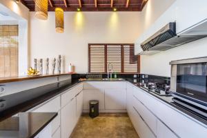 cocina grande con armarios blancos y microondas en Pristine Yuyu Villa Balian, en Balian