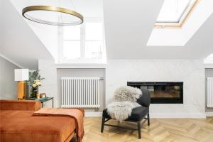 a living room with a chair and a fireplace at Penthouse Orzeszkowa by LoftAffair in Krakow