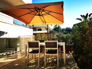 a table and chairs under an umbrella on a patio at Villa Amelie (Mare e Relax) in Bisceglie