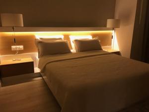a bedroom with a large bed with lights on it at Riverside apart in Blagoevgrad
