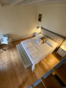 a large white bed in a room with a wooden floor at Antica Casa Fenaroli in Iseo
