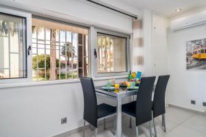 a dining room with a table and chairs and windows at ImpervillaStudio - Vilamoura City Centre in Quarteira +26 photos