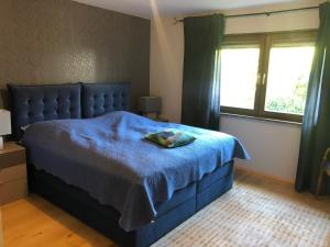 a bedroom with a blue bed with a blue blanket at Ausblick - Auszeit in Rimsting