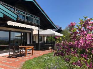 eine Terrasse eines Hauses mit einem Tisch und Stühlen in der Unterkunft Ausblick - Auszeit in Rimsting