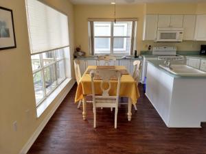 a kitchen with a table with a yellow table cloth on it at Seahorse Landing #503 Gulf Front Vacation Condo in Cedar Key