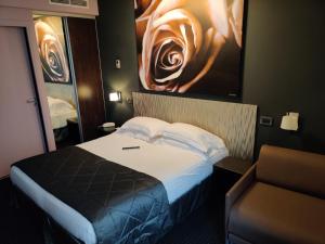 a bedroom with a bed and a painting on the wall at Hôtel Le Fabe in Paris