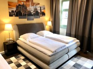 ein Bett in einem Schlafzimmer mit zwei Lampen und einem Fenster in der Unterkunft Markthof am Dom in Erfurt