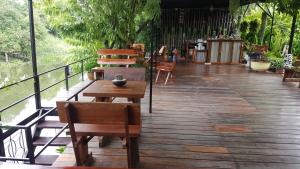 um deque de madeira com cadeiras e uma mesa e cadeiras em Baan Canalee (บ้านคานาลี) em Phra Nakhon Si Ayutthaya