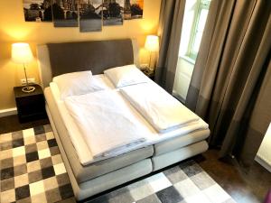 a bed with white sheets and pillows in a bedroom at Markthof am Dom in Erfurt