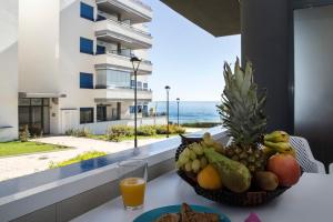 a bowl of fruit on a table with a view of the ocean at Apartamento Torrox in Torrox Costa