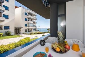 a table with a bowl of fruit on a balcony with the ocean at Apartamento Torrox in Torrox Costa