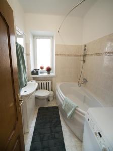 Un baño con bañera, inodoro y lavabo. en Petro delux apartments center, en Kaunas