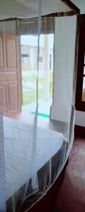 Cama en habitación con ventana en Exotic Beach Hotel, en Arugam Bay
