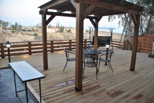 a gazebo with a table and chairs on a wooden deck at Marvin's Place in Arad