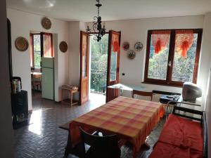 a living room with a table and a kitchen with windows at La Casa nel Verde in Alice Superiore