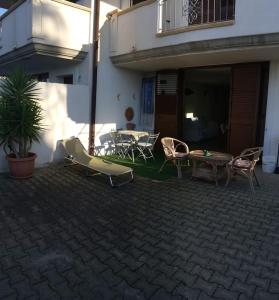 un patio con sillas y una mesa frente a un edificio en Summer Loft, en Tropea