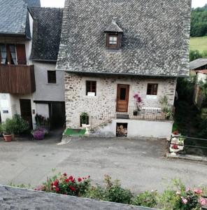 una antigua casa de piedra con techo gris en Le Fidèle, en Saint-Chamant