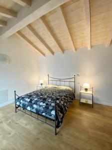 um quarto com uma cama preta num quarto branco em Casa BB em Gera Lario