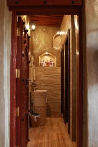 a hallway of a bathroom with a sink and a toilet at Bait Al Aqr in Nizwa