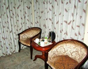 a table with two chairs and a tableasteryasteryasteryasteryasteryasteryasteryastery at Art Lodges in Harare