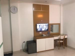 Habitación con escritorio, TV y espejo. en Linh Anh Hotel, en Hanói