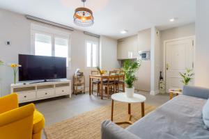 - un salon avec un canapé et une télévision dans l'établissement Apartamentos Circulo De Artistas, à Ronda