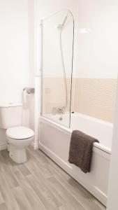 uma casa de banho branca com um WC e um chuveiro em Seymour Road - Birmingham BnBs em Oldbury