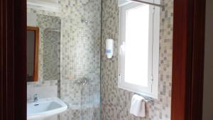 ein Bad mit einem Waschbecken und einem Spiegel in der Unterkunft Hostal Arias in Zafra