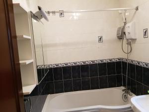 a bathroom with a bath tub and a sink at Spacious Bungalow in Romford with parking in Romford +13 photos