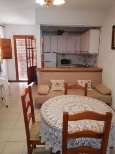 a living room with a table and a kitchen at Apartamentos Cerro Negro - Las Viñas in Capileira