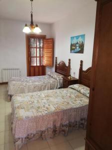 a bedroom with two beds and a window at Apartamentos Cerro Negro - Las Viñas in Capileira
