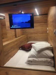 una stanza con una tv e un letto con cuscini di Capsule Hostel Top Wenceslas square a Praga