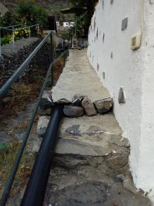 a wall with a fire hydrant next to a stone wall at La Cuadra in Hermigua