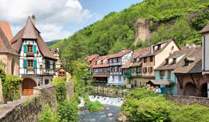 uma cidade com um rio e edifícios e uma montanha em Chez Filippa em Ostheim