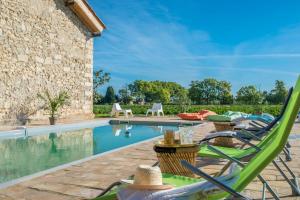 a patio with chairs and a swimming pool at Domaine la Clausade in Mauguio
