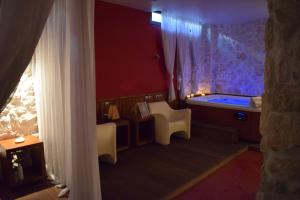 Zimmer mit Badewanne, Tisch und Stühlen in der Unterkunft Hagiati Anastasiou Hotel & Spa in Náousa (Imathia)