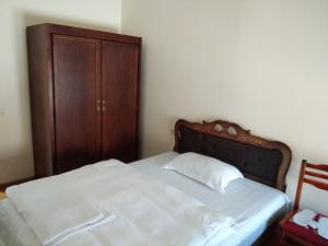 1 dormitorio con 1 cama y armario de madera en DownTown B&B en Vanadzor