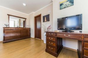 a living room with a television on a wooden dresser at Super comfort flat for you near the metro. in Kyiv