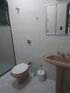a bathroom with a toilet and a sink at Casa linda e confortável a 3 min da praia!!! in Peruíbe
