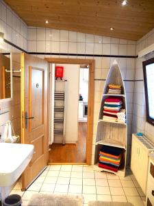 a bathroom with a sink and a shelf with towels at CASA LOFT & LaMansarda in Zirndorf